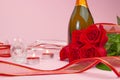 A composition of a beautiful bouquet of roses, candles, glasses and a bottle of champagne creates a romantic card. The concept of Royalty Free Stock Photo