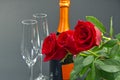 A composition of a beautiful bouquet of roses, glasses and a bottle of champagne creates a romantic card. The concept of st Royalty Free Stock Photo