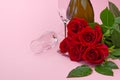 A composition of a beautiful bouquet of roses, candles, glasses and a bottle of champagne creates a romantic card. The concept of Royalty Free Stock Photo