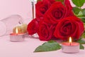 A composition of a beautiful bouquet of roses, candles, glasses and a bottle of champagne creates a romantic card. The concept of Royalty Free Stock Photo