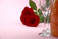 A composition of a beautiful bouquet of roses, glasses and a bottle of champagne creates a romantic card or poster. The concept of Royalty Free Stock Photo