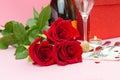 A composition of a beautiful bouquet of roses, glasses and a bottle of champagne creates a romantic card or poster. The concept of Royalty Free Stock Photo