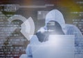 Composition of binary coding and data processing over hacker in hood and gloves using laptop Royalty Free Stock Photo