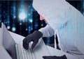 Composition of binary coding over hacker in hood and gloves using laptop Royalty Free Stock Photo