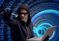 Composition of binary coding over hacker in hood using laptop Royalty Free Stock Photo