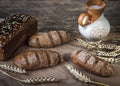 Composition black bread on the board, vintage knife, milk, wheat flakes, nuts on the table and the old background, concept of heal