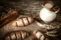 Composition black bread on the board, vintage knife, milk, wheat flakes, nuts on the table and the old background, concept of heal Royalty Free Stock Photo