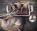 Composition black bread on the board, vintage knife, milk, wheat flakes, nuts on the table and the old background, concept of heal Royalty Free Stock Photo