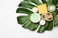 Composition with body care products, wisp and green leaf on white background, top view