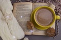 Composition of book with cup of coffee and Christmas decorations on table on gray background Royalty Free Stock Photo