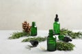 Composition with bottle of conifer essential oil on light table Royalty Free Stock Photo