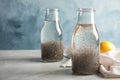 Composition with bottles of water and chia seeds on table against color background. Royalty Free Stock Photo