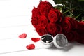 Composition from a bouquet of beautiful red roses and a gift jewelry box on the background. Royalty Free Stock Photo