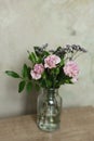 Bouquet of pink carnation flowers in a glass vase on the table Royalty Free Stock Photo