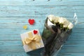 Composition of a bouquet of red roses, gift box on a blue wooden background, Valentine`s Day. Royalty Free Stock Photo