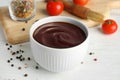 Composition with bowl of barbecue sauce on wooden table Royalty Free Stock Photo