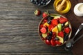 Composition bowl of fresh fruit salad on wooden background, top view Royalty Free Stock Photo