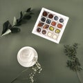 Composition with a box of coffee chocolates and flowers Royalty Free Stock Photo