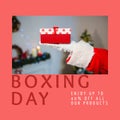 Composition of boxing day sales text over santa claus holding christmas present Royalty Free Stock Photo