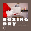 Composition of boxing day sales text over santa claus holding christmas present Royalty Free Stock Photo