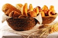 Composition with bread and rolls in wicker basket, combination of pastries for bakery or market with wheat Royalty Free Stock Photo