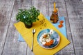 A composition of breakfast. Bowl of ice cream, tiny tree, bottle of apricot juice on a table background. Healthy brunch.