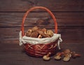 Composition in brown colors with a basket with wild mushrooms Xerocomus on the dark rustic wooden table. Seasonal harvesting in