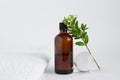 composition of brown glass jar, glass ball and green leaves on a white background. natural self-care