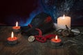 A composition of burning candles, an amulet with a Yggdrasil tree, an old leather bag for Scandinavian runes.