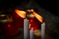 Composition burning white candle.  In the background, a blurred background with burning candles, beads. concept of magic, faith Royalty Free Stock Photo