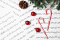Composition with candy canes and Christmas balls on music sheets Royalty Free Stock Photo