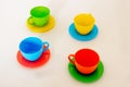 Composition from a children`s plastic service, consisting of four multi-colored tea cups with saucers Royalty Free Stock Photo