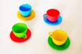 Composition from a children`s plastic service, consisting of four multi-colored tea cups with saucers Royalty Free Stock Photo