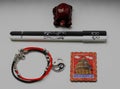 A composition of a Chinese red tortoise figurine, a black and white pen, a bracelet with a yin yang symbol and a metal magnet.