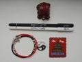 A composition of a Chinese red tortoise figurine, a black and white pen, a bracelet with a yin yang symbol and a metal magnet.