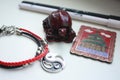 A composition of a Chinese red tortoise figurine, a black and white pen, a bracelet with a yin yang symbol and a metal magnet.
