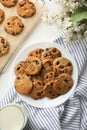 Composition with chip cookies flowers and milk on white table, top view