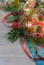 Composition of Christmas decorations on a wooden neutral background. Holly, ivy, candle, green and red colors on a pale Royalty Free Stock Photo