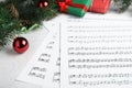 Composition with Christmas music sheets with notes on white wooden background, closeup Royalty Free Stock Photo