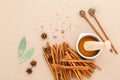 Composition of cinnamon stick and cinnamon powder in white mortar with star anise ,bay leaves and wooden spoon on brown Royalty Free Stock Photo