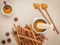 Composition of cinnamon stick and cinnamon powder in white mortar with star anise ,bay leaves and wooden spoon on brown Royalty Free Stock Photo