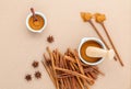 Composition of cinnamon stick and cinnamon powder in white mortar with star anise and wooden spoon on brown background . Royalty Free Stock Photo