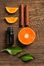 Composition with citrus essential oil, cinnamon sticks and orange slices on wooden table, top view Royalty Free Stock Photo