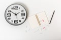 Composition with clock, notepad, paper clips and pencil. white background,flat lay. businnes concept