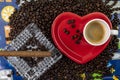 Composition of coffee beans with heart shaped cup and saucer