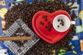 Composition of coffee beans with heart shaped cup and saucer