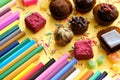 Composition of colored pencils and beautiful sweets Royalty Free Stock Photo