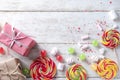 Composition with colorful candies and gift boxes on light wooden background Royalty Free Stock Photo