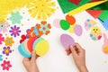 Composition of colorful Easter eggs, flowers, sun, chicken, rabbit from multi-colored paper, step by step. Child makes crafts his Royalty Free Stock Photo