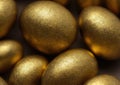 Composition of coloured and golden eggs, with artistic decorations, with depth of field, photographic lighting and close-ups.
